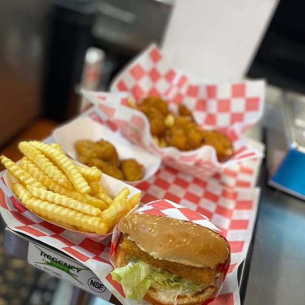 Five Star Burger's crispy chicken sandwich, crinkle-cut fries, and chicken nuggets in checkered paper.